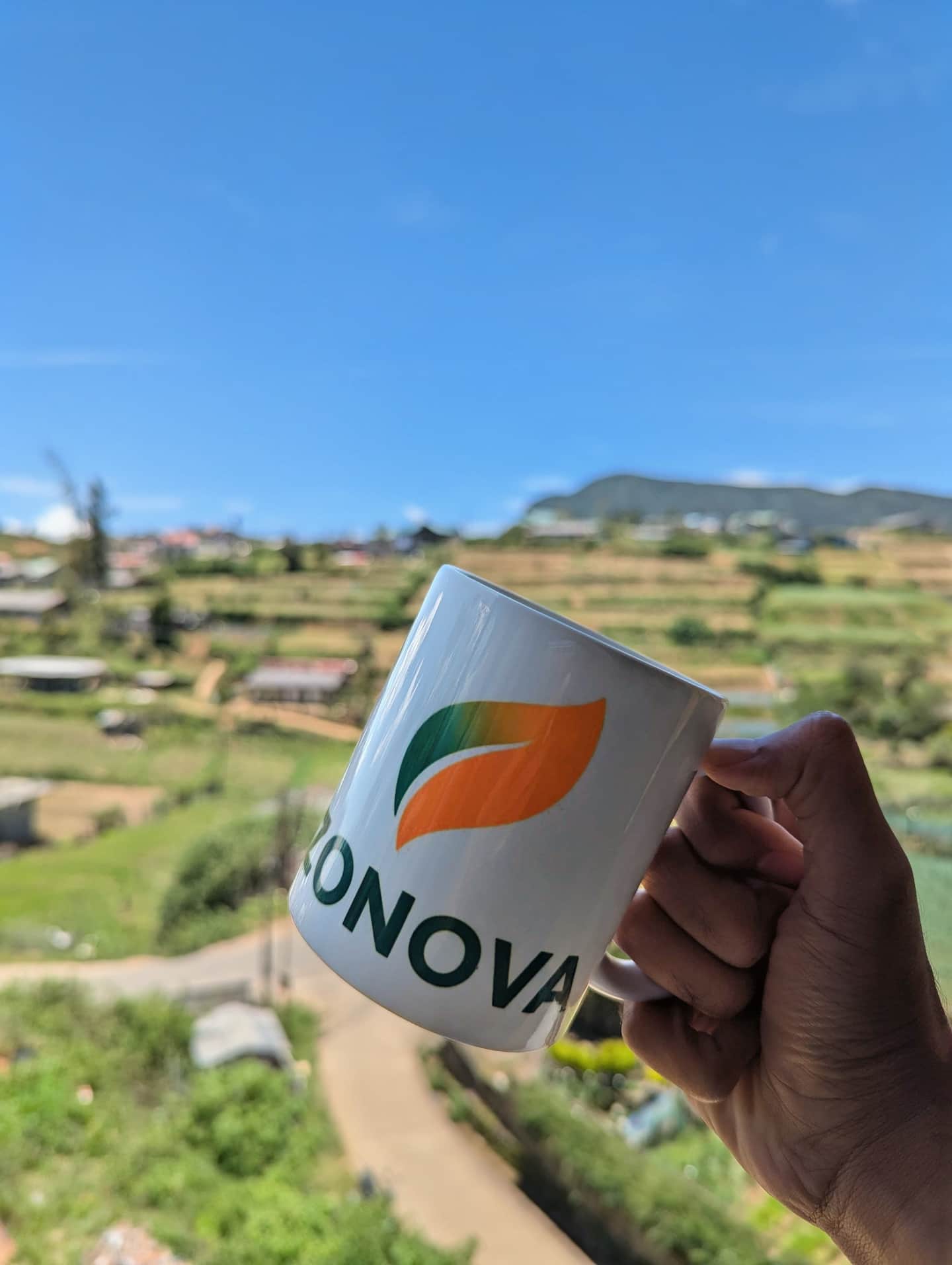 A Zonova mug held up against the hill-country view
